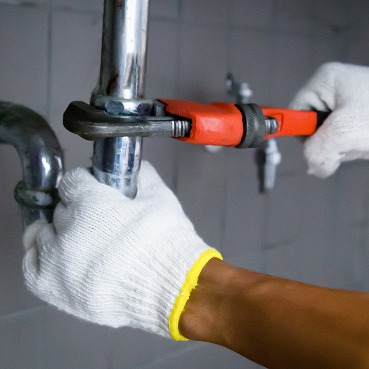 Plumber repairing leaky water pipe.