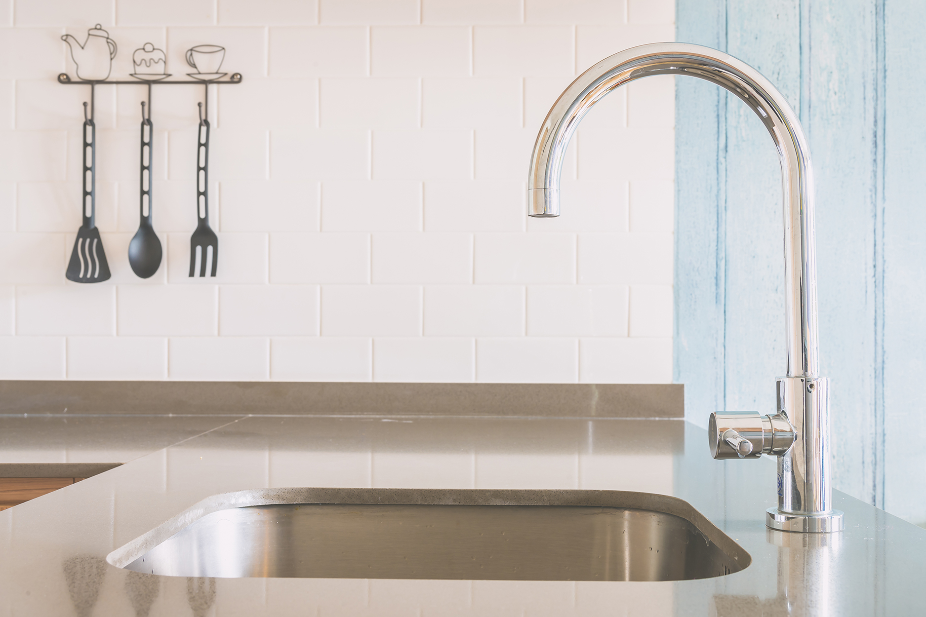 A silver new faucet installation in a clean and modern space. 